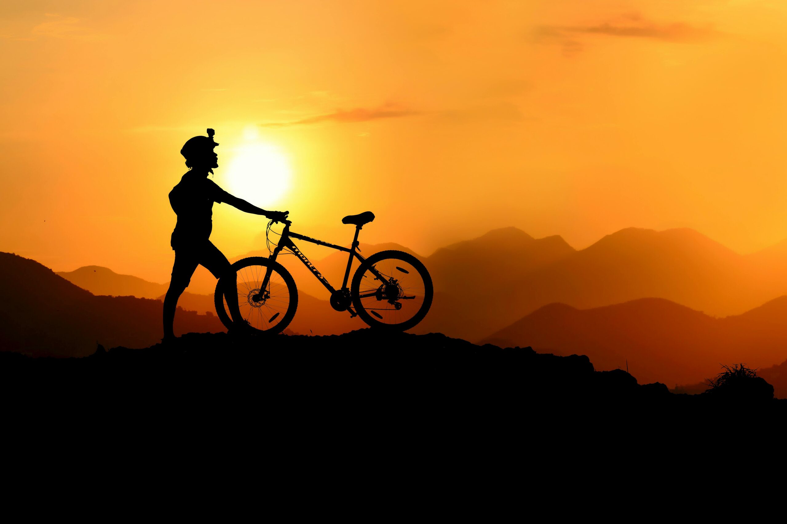 Vététiste sur un sommet admirant un coucher de soleil